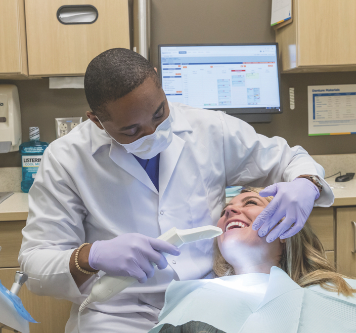 A specially trained dentist from Aspen is doing a scan of the patient’s mouth for dental implants.