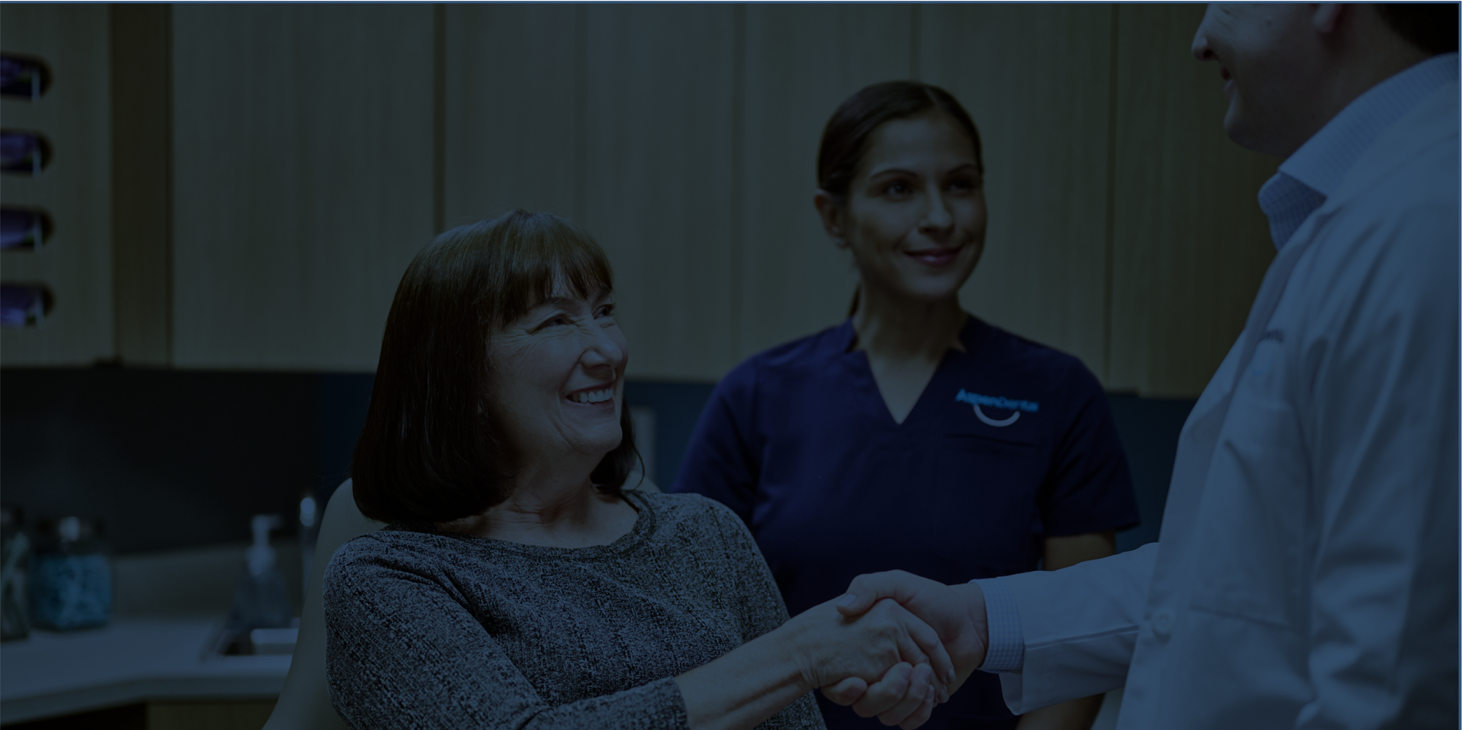 An Aspen Dental doctor shakes hands with a patient. 
