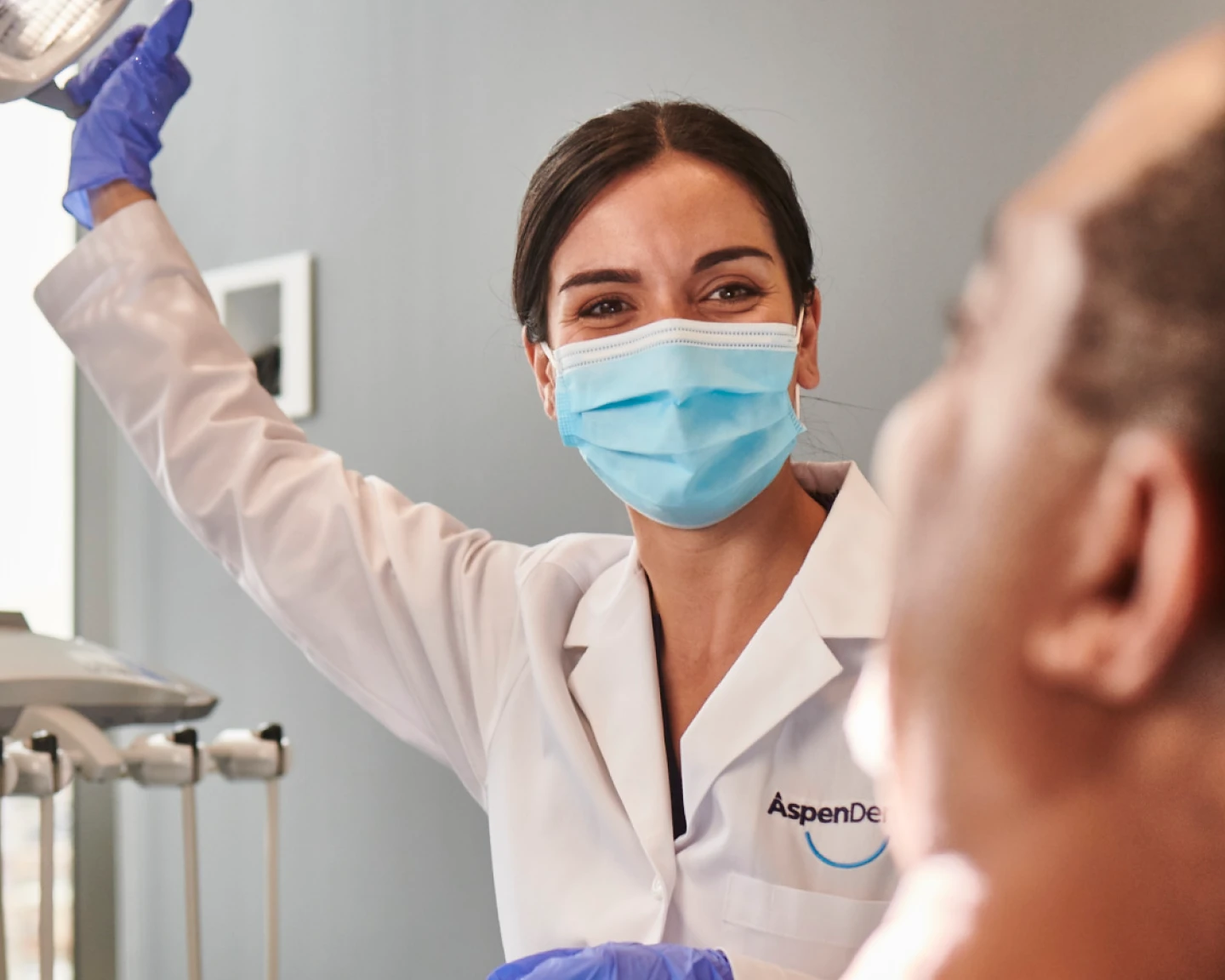 An Aspen Dental doctor prepares for a dental exam. 